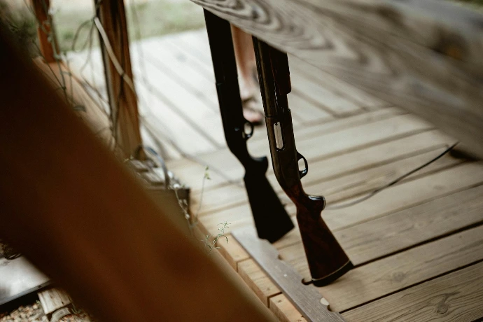 A couple of guns sitting on top of a wooden floor